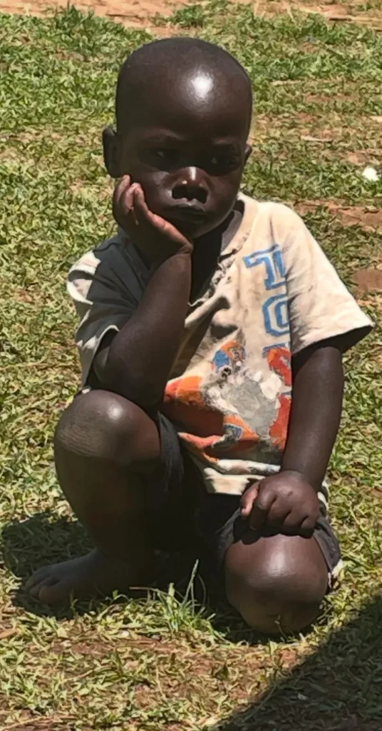 Jongetje zit op de grond met zijn hand onder zijn hoofd